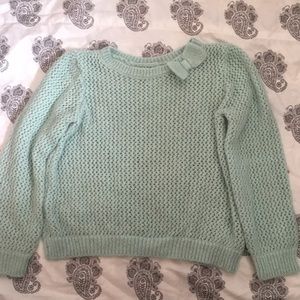 A knitted teal kids sweatshirt.